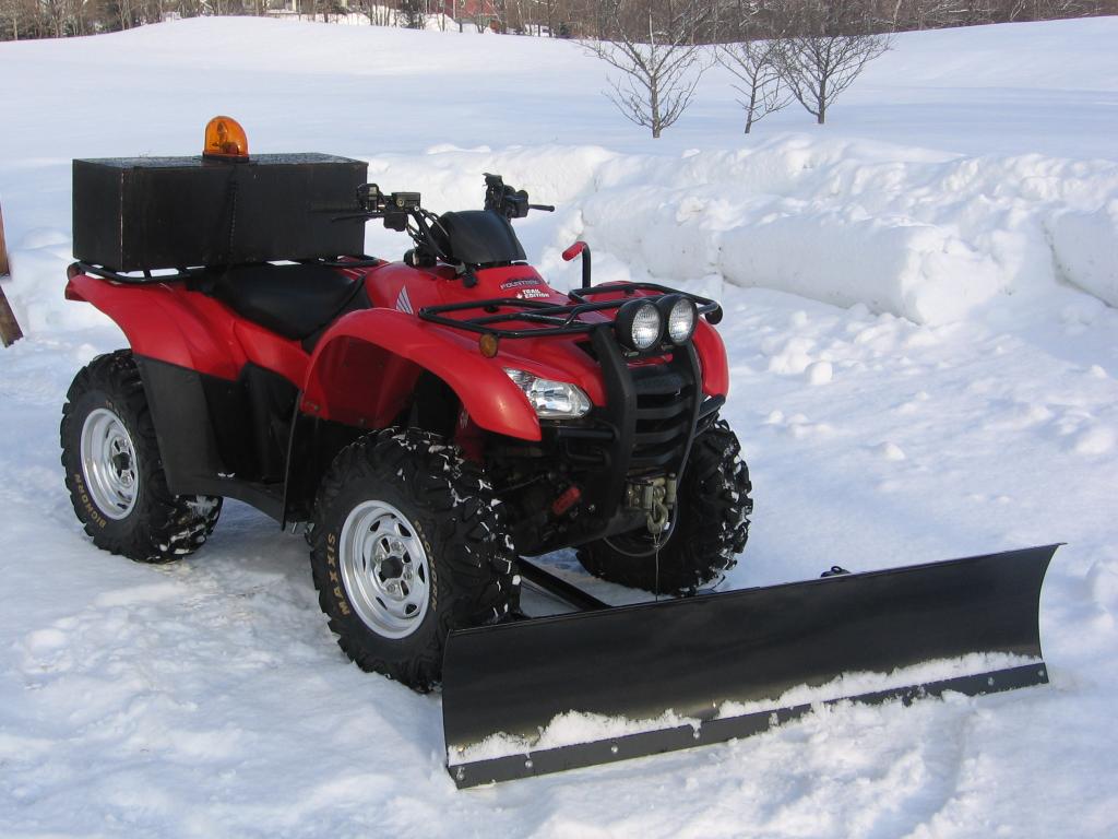  ATV with led lights in the snow with a plow