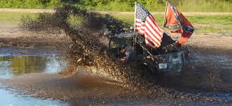 Jeep mudding with huge American and Rebel flags