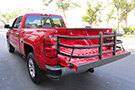 Black Amp Research BedXTender HD Max installed on a red pickup truck's bed area
