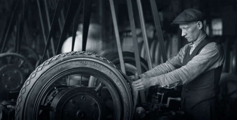 Photo of a worker from the old days check a tire