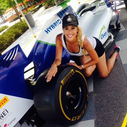 Woman kneeling in front of an Indycar with Pierlli tires